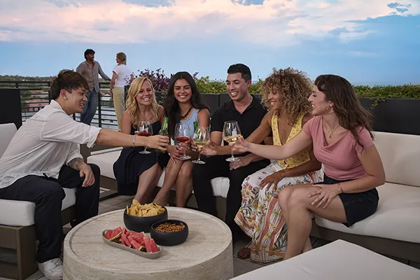 The Astrie residents gathering with drinks on a rooftop terrace in Tucson