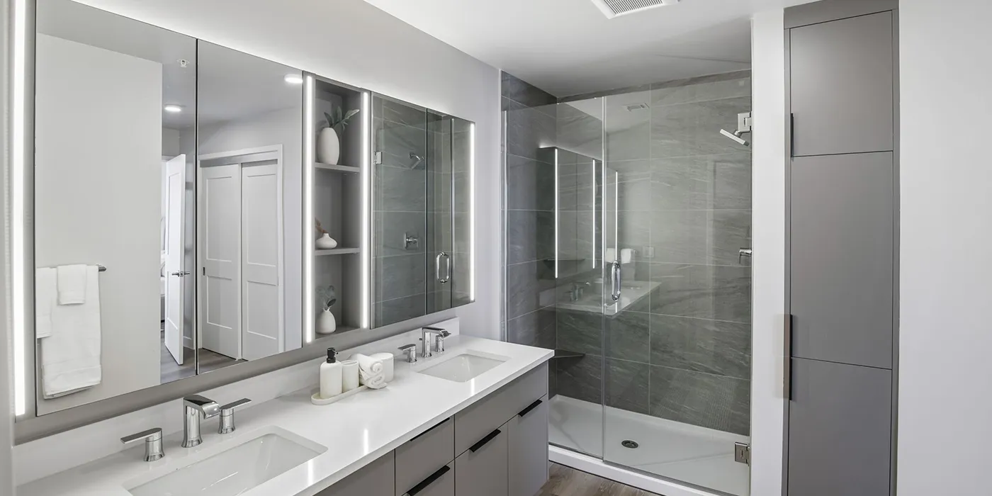 Spa-inspired bathroom at The Astrie with double vanity and glass shower enclosure