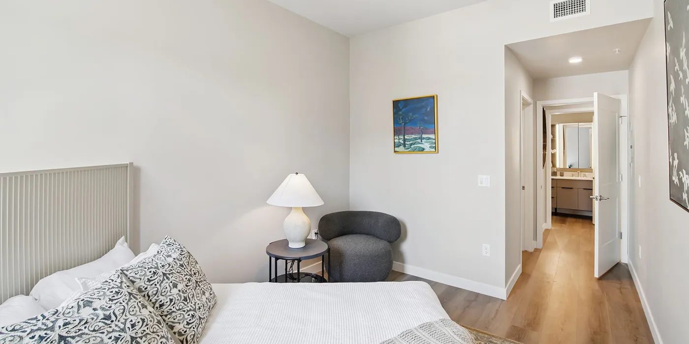 Refined bedroom interior at The Astrie with wood-style flooring and contemporary design